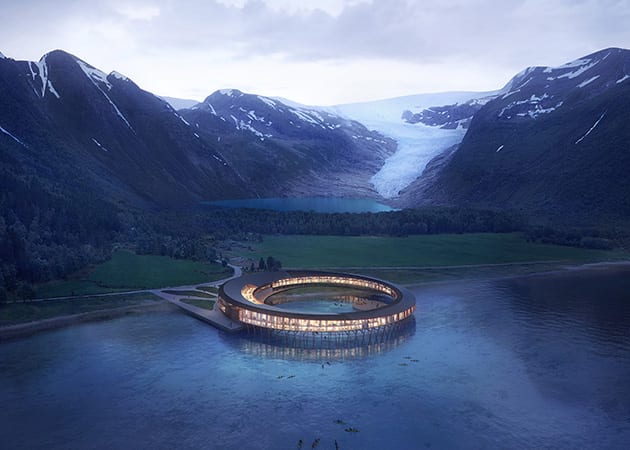 circular hotel on norwegian lake surrounded by mountains 