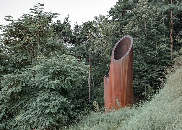 corten steel chimney coming out of the ground - iconeye.com